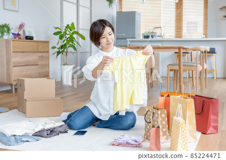 Housewife organizing clothes in the living room 85224471