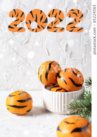 Tangerines with painted stripes. The concept for the tiger new year with a Christmas tree. Tiger mandarines 85224565
