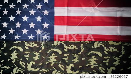 American flag and Military camouflage pattern. Top view angle. Soldier flag with national American flag on white background. Represent military concept by camouflage fabric and USA national flag. 85226027
