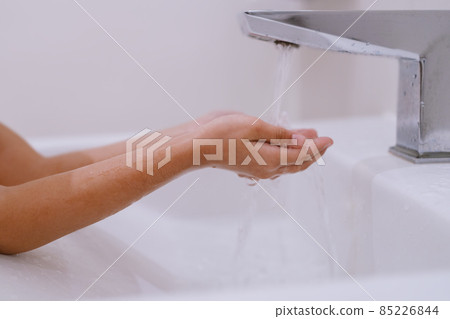 A girl washing her hands at the sink. A girl washing her hands at the sink. 85226844