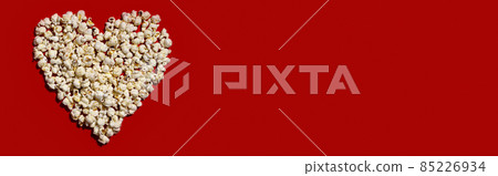 Heart made of popcorn on red background Heart made of popcorn on red background 85226934