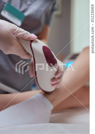 Young woman getting laser hair removal on her thighs. Young woman getting laser hair removal on her thighs. 85228069