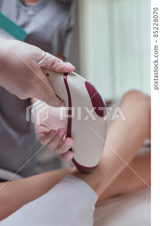 Young woman getting laser hair removal on her thighs. Young woman getting laser hair removal on her thighs. 85228070