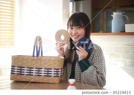 一位女士展示用工藝帶製作的籃子 一位女士展示用工藝帶製作的籃子 85229813