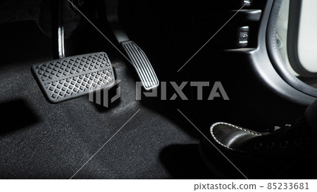 Accelerator and breaking pedal in a car. Close up the foot pressing foot pedal of a car to drive ahead. Driver driving the car by pushing accelerator pedals of the car. Foot pedals inside vehicle. 85233681