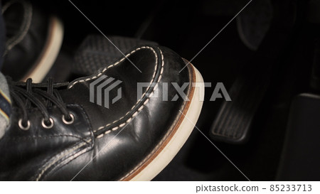 Accelerator and breaking pedal in a car. Close up the foot pressing foot pedal of a car to drive ahead. Driver driving the car by pushing accelerator pedals of the car. Foot pedals inside vehicle. 85233713