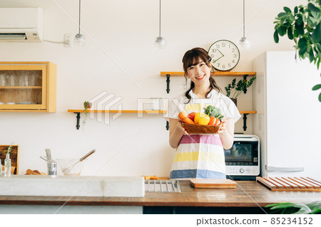 拿著菜的婦女在廚房裡 拿著菜的婦女在廚房裡 85234152