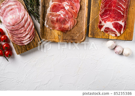 Cold smoked meat slices prosciutto, on white stone table background, top view flat lay, with copy space for text Cold smoked meat slices prosciutto, on white stone table background, top view flat lay, with copy space for text 85235386