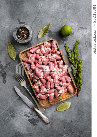 Raw uncooked chicken gizzards, chicken hearts, on gray stone table background, top view flat lay 85235391