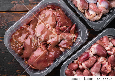 Fresh turkey industrial production, farm turkey liver in a vacuum, on old dark wooden table background, top view flat lay Fresh turkey industrial production, farm turkey liver in a vacuum, on old dark wooden table background, top view flat lay 85235392