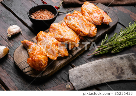 Chicken meat wings marinated and legs for BBQ, on old dark wooden table background Chicken meat wings marinated and legs for BBQ, on old dark wooden table background 85235433