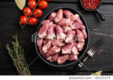 Raw poultry hearts offal with herbs, on black wooden table background, top view flat lay Raw poultry hearts offal with herbs, on black wooden table background, top view flat lay 85235574