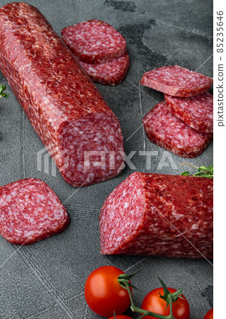 Dry salami sausage with fresh rosemary and spices, on gray stone table background 85235646