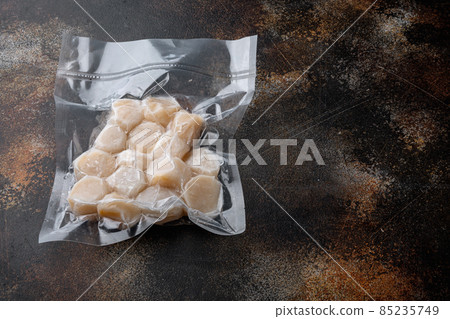 Frozen meat scallop in vacuum package, on old rustic background with space for text Frozen meat scallop in vacuum package, on old rustic background with space for text 85235749
