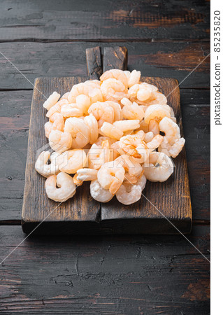 Boiled Peeled Shrimps, Prawns, on wooden serving board, on old dark wooden table Boiled Peeled Shrimps, Prawns, on wooden serving board, on old dark wooden table 85235820