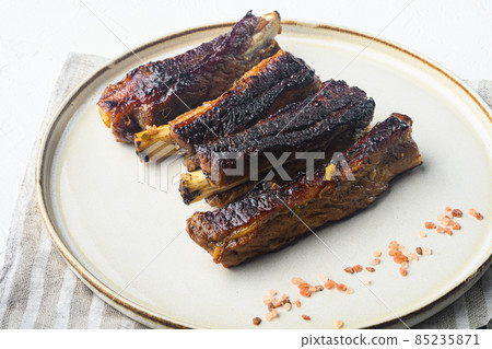 Pork ribs grilled with BBQ sauce and caramelized in honey, on plate, on white stone background 85235871
