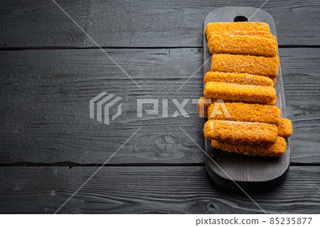 Frozen fish sticks. Organic fish food, on wooden cutting board, on black wooden table background , with copyspace and space for text Frozen fish sticks. Organic fish food, on wooden cutting board, on black wooden table background , with copyspace and space for text 85235877
