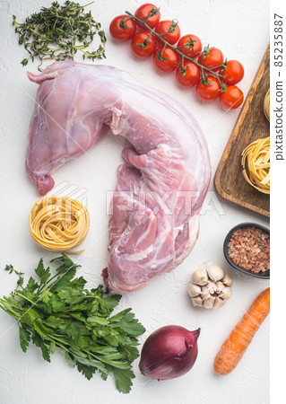 Whole rabbit, Raw meat with spices and vegetables, ingredients for stewing, on white stone background, top view flat lay Whole rabbit, Raw meat with spices and vegetables, ingredients for stewing, on white stone background, top view flat lay 85235887