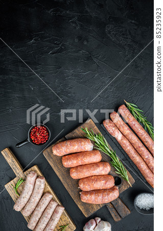 Assorted fresh raw pork, beef and chicken sausages, top view with space for text, on black background 85235923