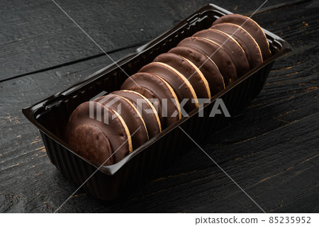 Chocolate Covered Marshmallow Biscuits,in plastic tray container, in plastic tray container, on black wooden background Chocolate Covered Marshmallow Biscuits,in plastic tray container, in plastic tray container, on black wooden background 85235952