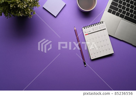 Top view calendar, laptop computer and coffee cup on purple background. 85236556