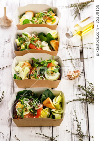 Delicious and healthy lunch with salmon fish fillet in a card box. Salad with smoked salmon, cheese, eggs, onion and vegetables. Seafood diet. Organic Mediterranean eat. Takeaway food. Vertical shot Delicious and healthy lunch with salmon fish fillet in a card box. Salad with smoked salmon, cheese, eggs, onion and vegetables. Seafood diet. Organic Mediterranean eat. Takeaway food. Vertical shot 85239159