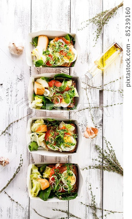 Delicious and healthy lunch with salmon fish fillet in a card box. Salad with smoked salmon, cheese, eggs, onion and vegetables. Seafood diet. Organic Mediterranean eat. Takeaway food. Vertical Banner 85239160