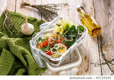 Delicious and healthy lunch with salmon fish fillet in a glass lunch box. Salad with smoked salmon, soft cheese, eggs, onion and vegetables. Seafood diet. Natural organic food Mediterranean lunch Delicious and healthy lunch with salmon fish fillet in a glass lunch box. Salad with smoked salmon, soft cheese, eggs, onion and vegetables. Seafood diet. Natural organic food Mediterranean lunch 85239165