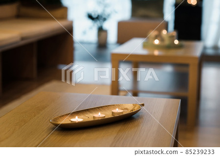 Burning candles are on the table in the room.Atmospheric interior lighting Burning candles are on the table in the room.Atmospheric interior lighting 85239233
