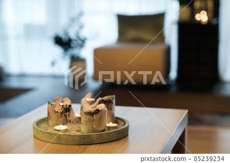 Burning candles are on the table in the room.Atmospheric interior lighting Burning candles are on the table in the room.Atmospheric interior lighting 85239234