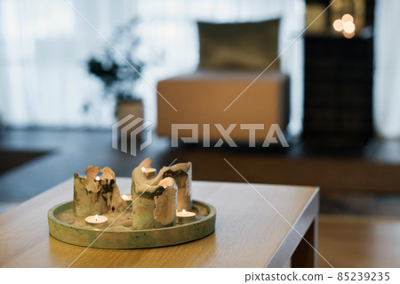 Burning candles are on the table in the room.Atmospheric interior lighting Burning candles are on the table in the room.Atmospheric interior lighting 85239235
