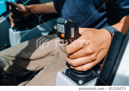 Close-up of a hand holding a joystick to control a crane.Construction concept 85239253