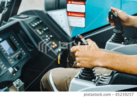 Close-up of a hand holding a joystick to control a crane.Construction concept 85239257