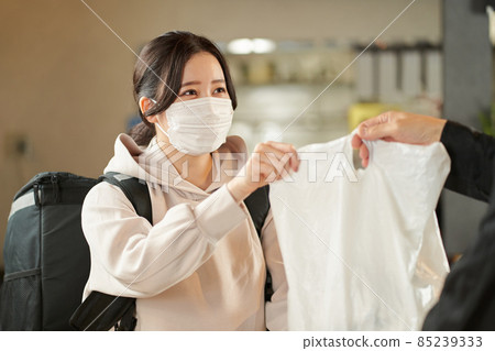 Asian female receiving a meal to deliver 85239333