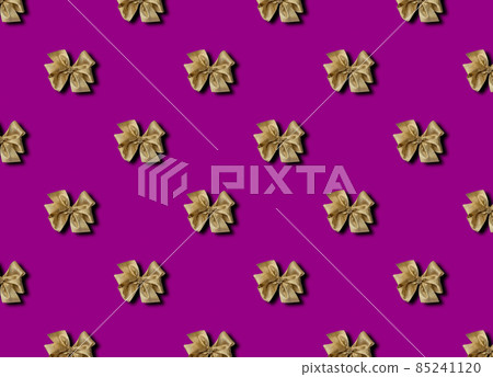 Golden bow for decorating gifts on a purple background. Beautifully tied bow. Photo of a gift package with a seamless pattern. Golden bow for decorating gifts on a purple background. Beautifully tied bow. Photo of a gift package with a seamless pattern. 85241120