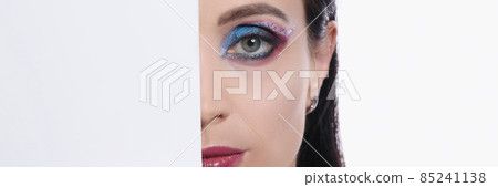 Half face of young sexy woman with burgundy lipstick and bright eye makeup closeup Half face of young sexy woman with burgundy lipstick and bright eye makeup closeup 85241138