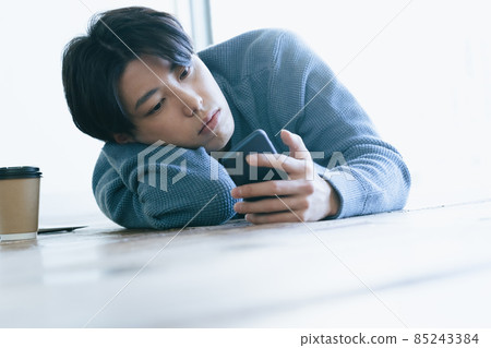 看智能手機的年輕人 85243384