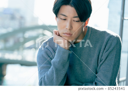 A young man looking out in a boring way 85243541