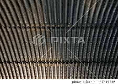 Detail shot of moving steps at the bottom of a conventional escalator with sensor. Detail shot of moving steps at the bottom of a conventional escalator with sensor. 85245136
