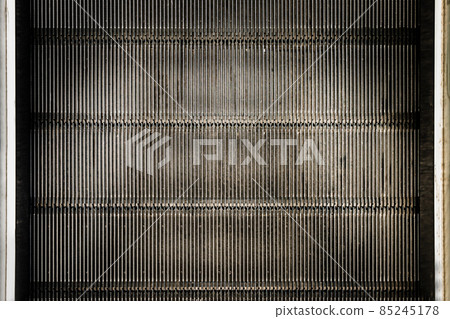 Detail shot of moving steps at the bottom of a conventional escalator with sensor. 85245178