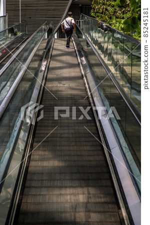 Modern escalator staircase with people for facilities in a contemporary building. 85245181