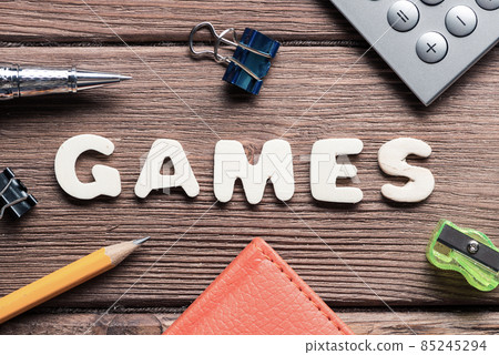 Game word on wooden table and office stationary around Game word on wooden table and office stationary around 85245294