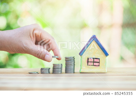 Men's hand is place on the coins. Indicates savings in order to buy a home. Men's hand is place on the coins. Indicates savings in order to buy a home. 85245355
