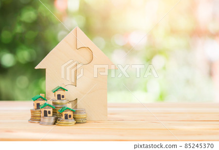 House placed on coins. house puzzles on the wooden table. planning savings money of coins to buy a home House placed on coins. house puzzles on the wooden table. planning savings money of coins to buy a home 85245370