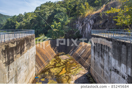 Dried up empty reservoir or small concrete dam due to a summer heatwave. Dried up empty reservoir or small concrete dam due to a summer heatwave. 85245684