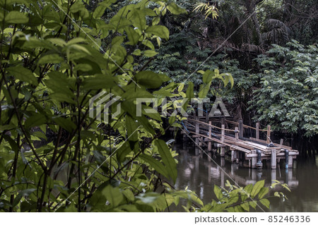 A wooden bridge over a small river. A wooden bridge over a small river. 85246336