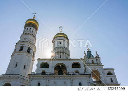 Ivan the Great Bell Tower, with Assumption Belfry on the right in Moscow Kremlin. Blue sky background with sunbeams 85247999