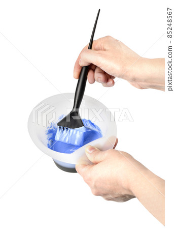 Female hand in gloves dips with brush for hair coloring, 85248567