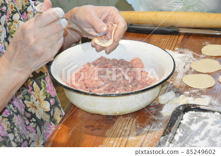 Woman sculpts dumplings at home 85249602
