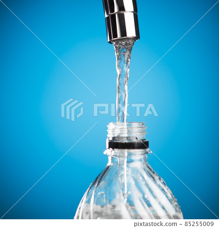 pouring a bottle of water from mixer tap pouring a bottle of water from mixer tap 85255009